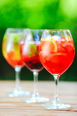 Summer cocktail. Fruit cocktail on green background. Citrus fruits, berries, strawberries, blueberries, mint, ice.