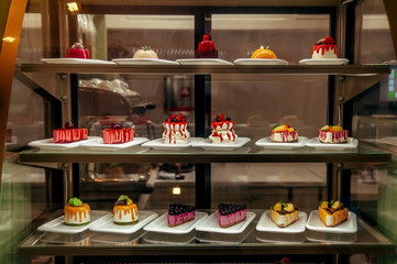 many little cakes beyond showcase in shop is on sale