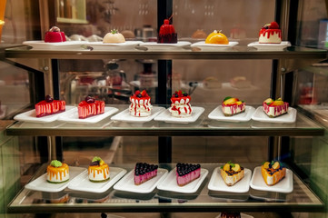 many little cakes beyond showcase in shop is on sale