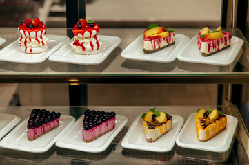 many little cakes beyond showcase in shop is on sale