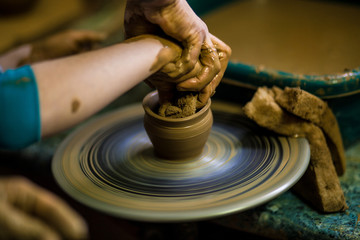 Creating jar or vase of clay close-up. Master crock. Man hands making clay jug macro. sculptor in workshop jug out of earthenware closeup. Twisted potter's wheel