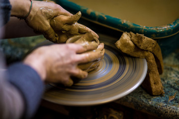Creating jar or vase of clay close-up. Master crock. Man hands making clay jug macro. sculptor in workshop jug out of earthenware closeup. Twisted potter's wheel