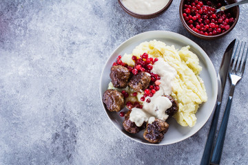 Homemade beef and pork meatballs with mashed potatoes and lingonberry sauce on a gray stone concrete background table. Lunch Dinner Food Concept. Top view, copy space