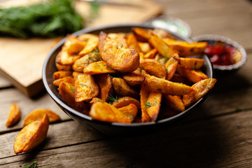 Baked potato fries on wooden table
