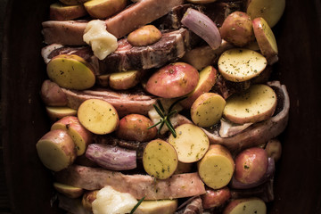 Lamb Loin Chops with Vegetables in Rustic Clay Dish Prepared for Roasting. Copy Space.