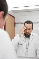 Arzt mit Burnout Syndrom durch Stress, Übermüdung und Zeitdruck