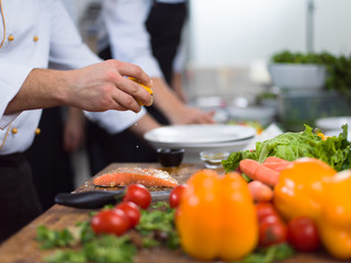 Chef hands preparing marinated Salmon fish