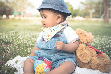 Cute little asian baby sitting in garden,vintage ton