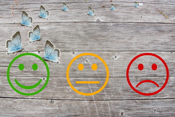 Review classification with happy and angry faces on wooden background