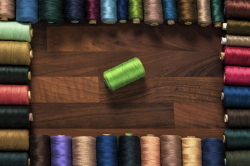 a lot of threads on the wooden table