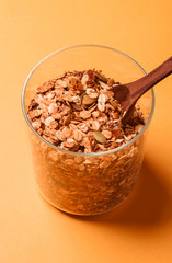 Granola in a glass jar on a yellow background