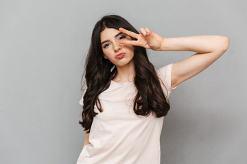 Fototapeta premium Pretty cute young lady showing peace gesture.
