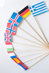 Bunch of miniature paper flags of several countries: Greece,Germany,Sweden,Norway,England,Italy,France,Spain, Russia