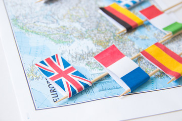 Fototapeta na wymiar Colored flags of Europian countries on a map: France, Italy, England UK, Spain, Greece, travel destination planning concept