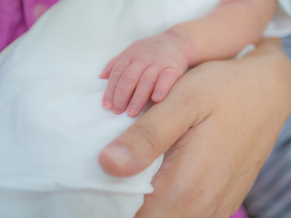 mother day and new born concept from mother's hand hold with small baby foot and hand with soft focus background