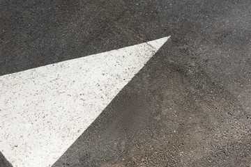 Fototapeta premium White painted arrow on asphalt road
