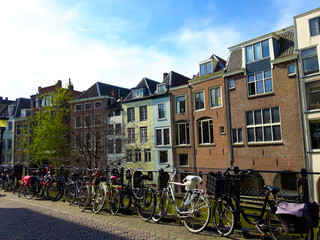 Fototapeta na wymiar Bicycles against a fence along a Dutch canal with canal houses. Utrecht, The Netherlands, Europe.