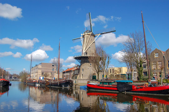 Windmill De Roode Leeuw and antique ships in canal. Turfsingel Gouda, the Netherlands.
