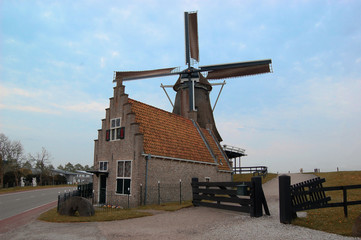 Typical Dutch house and mill at a dike. Medemblik, the Netherlands.