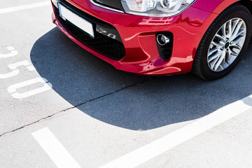 Obraz na płótnie Canvas Close-up view of red car on street parking lot
