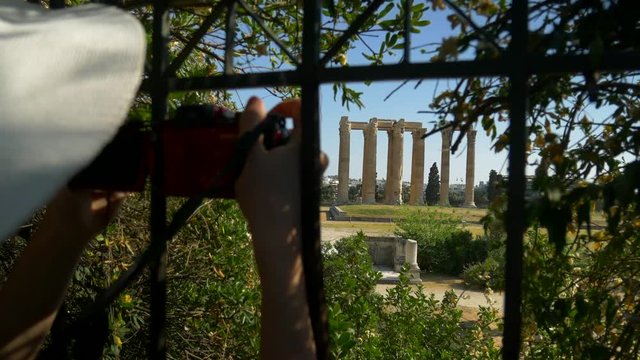 Woman taking photograph with camera at the Temple of Olympian Zeus, Athens