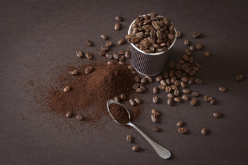 Coffee beans and ground powder on brown background.