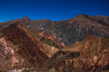 View of Iruya village and multicolored mountains in the surroundings at sunset, Salta province, Argentina, iruya - San Isidro - San Juan treeking