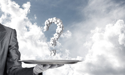 Hand of waiter presenting question mark on tray.