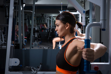 Athletic young woman works out on training apparatus in gym class. Halthy concept.