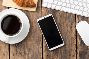 Blank screen smart phone and computer on wooden table top view.