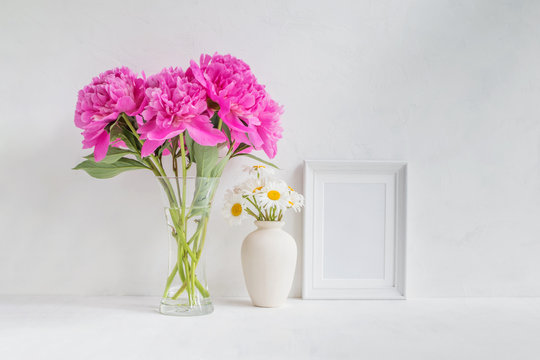 Mockup with a white frame and pink peonies