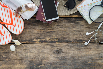 Holidays concept, Preparation for travel,smartphone and passport with glasses and flip flops on old wooden table