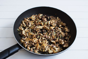 Fried chopped oyster mushrooms onion pan selective focus.