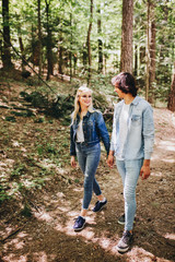 Obraz premium Young couple walking, hand in hand, through forest