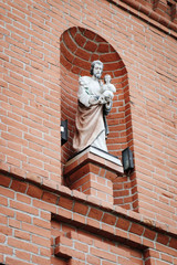 Naklejka premium Religious sculptures on the brick wall, house of the sisters of the Order of Saint Ursula in the historic district of Kamianets-Podilskyi, Ukraine