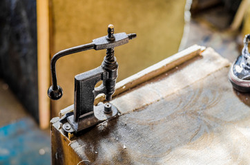 Vintage hand-press for setting rivets on clothes. The shoemaker's workshop.