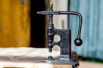 Vintage hand-press for setting rivets on clothes. The shoemaker's workshop.