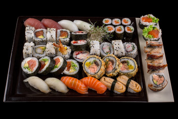 Large sushi set on the black background.