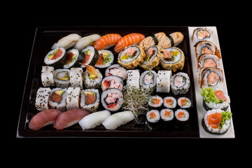 Large sushi set on the black background.