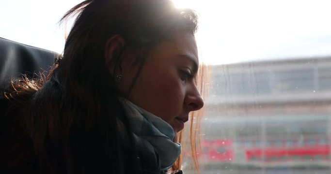 Woman riding train commuting to work or study. Girl looking down on a moving transportation