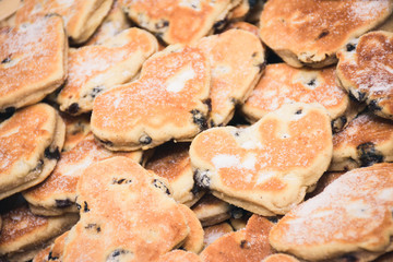Traditional Welsh cakes with raisins and powdered sugar macro in heart shapes