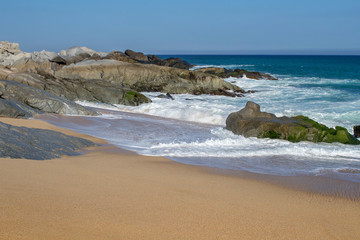 Rocks and small waves on the beach in Mexico