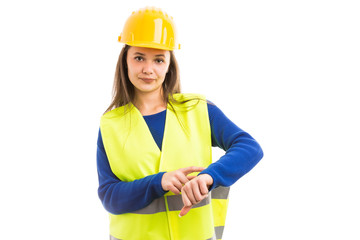 Young female engineer making late time gesture.