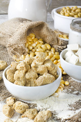 Ecological texturized soy meat with soy beans and tofu on rustic background