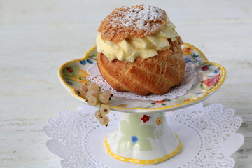 French dessert - eclair with custard and sugar powder