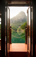 Fototapeten Sunset view through a boat door over a lake in China © creativefamily