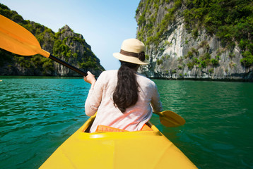 Girl kayaking on seaside of Halong bay in Vietnam