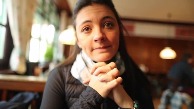 POV on a date, Young woman looking to camera holding hands and starring to date gives a slight smile