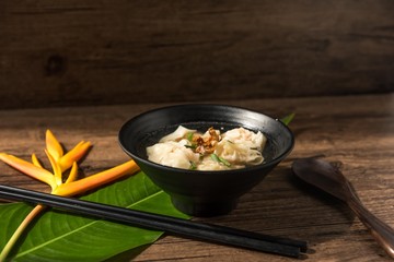 Shrimp wonton with braised pork in soup on wooden table - Asian food style  / Select focus image
