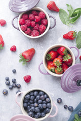 Summer fruit background, top view of berries , smoothie ingredient, inside ceramic colored cocotte, blueberries, strawberries, raspberries, flat lay